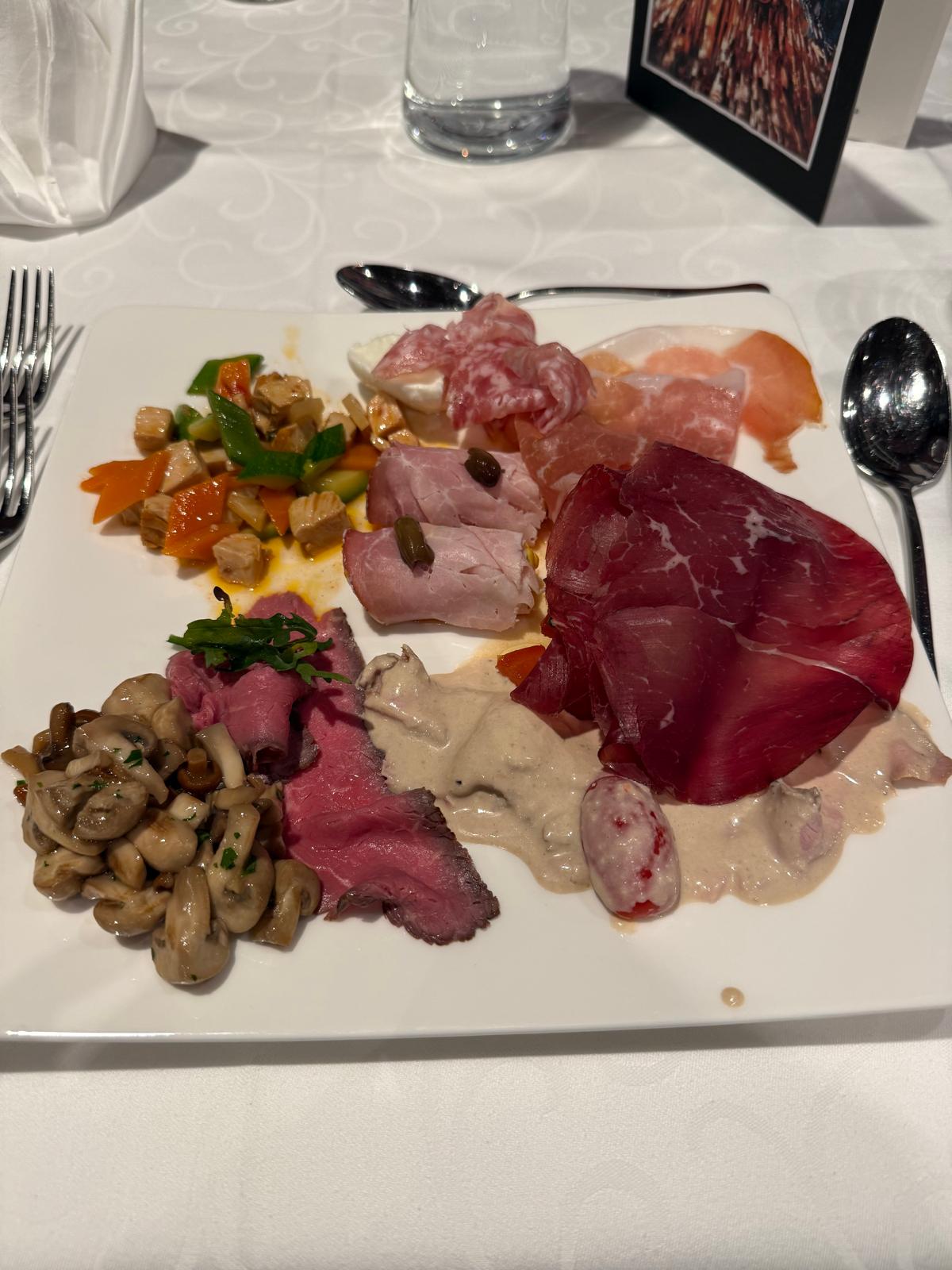 Un tagliere rustico con speck, formaggi locali, cetriolini, pane nero e rafano è il pranzo perfetto dopo una camminata in montagna o una giornata in malga.